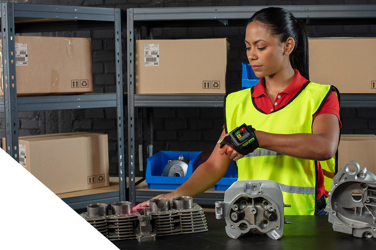 Eine Frau scannt ein Bauteil im Lager