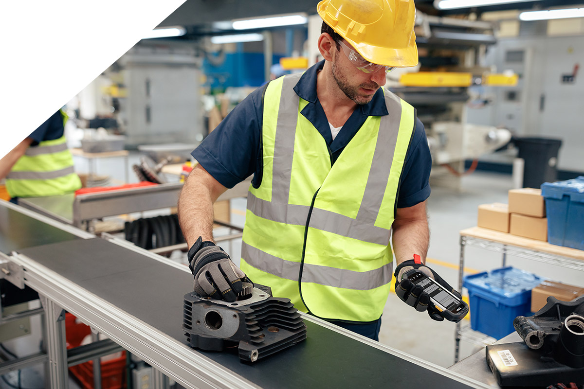 Ein Mann scannt ein Bauteil in der Produktion