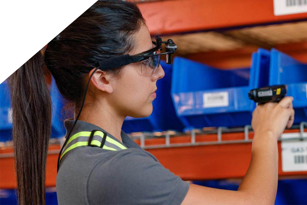 Eine Frau mit Datenbrille und Ringscanner scannt einen Barcode