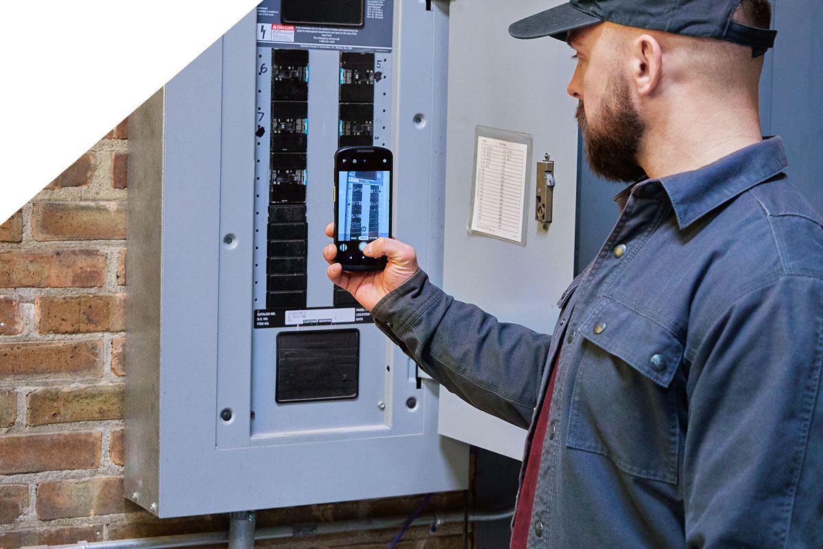 techniker dokumentiert zählerstände per fotofunktion auf mobilcomputer