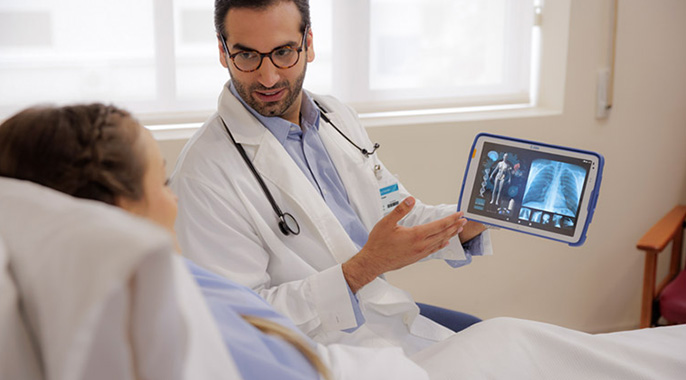 Ein Arzt zeigt einer Patientin ein Bild auf einem Tablet